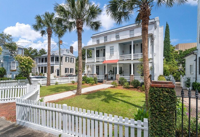 view of front of home with a porch, a front yard, and a balcony