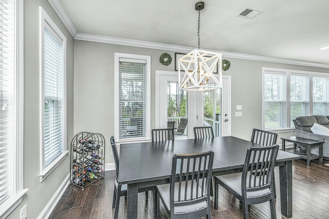 dining room with dark hardwood / wood-style flooring, crown molding, and a chandelier