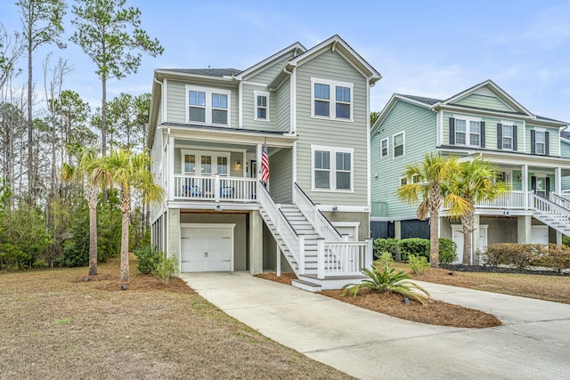 raised beach house featuring a garage and covered porch