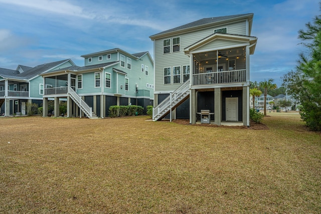 rear view of house featuring a lawn, a sunroom, and ceiling fan