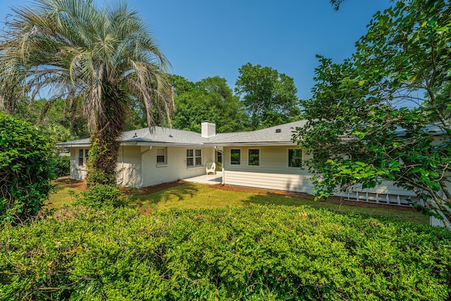 881 Evans Rd, Charleston, SC 29412 - back of house featuring a chimney, a patio, brick siding, and a yard