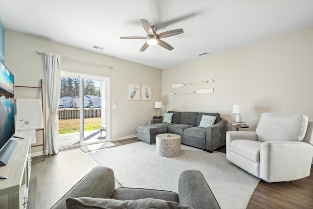 living area featuring visible vents, a ceiling fan, and wood finished floors