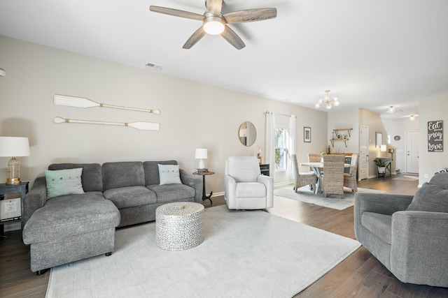 living area featuring visible vents, wood finished floors, and ceiling fan with notable chandelier