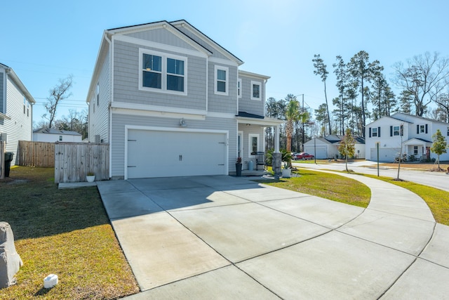 view of front of home featuring driveway, a front lawn, an attached garage, and fence