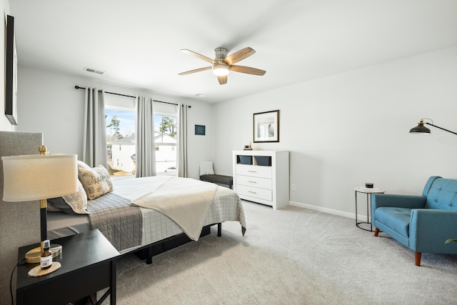 bedroom featuring visible vents, light carpet, baseboards, and a ceiling fan