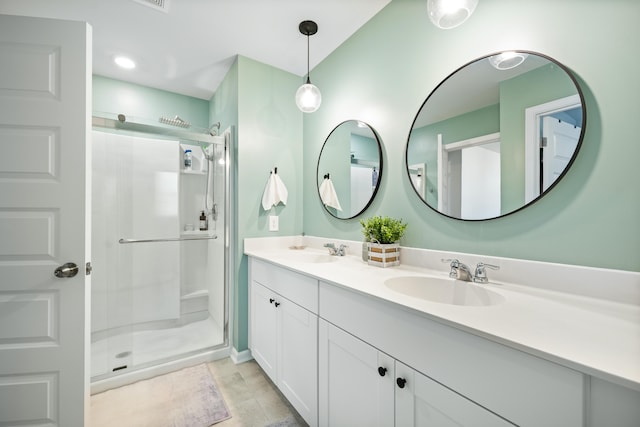 bathroom with a sink, double vanity, and a shower stall