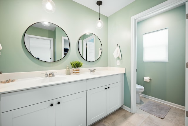 full bath featuring a sink, baseboards, toilet, and double vanity