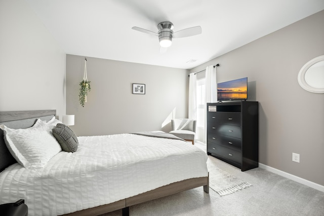 bedroom featuring baseboards, light colored carpet, and ceiling fan