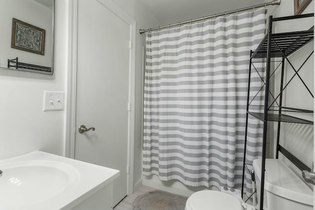 full bathroom featuring a sink, toilet, and shower / tub combo with curtain