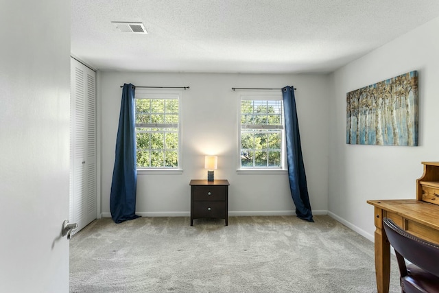 interior space featuring visible vents, a textured ceiling, baseboards, and carpet floors