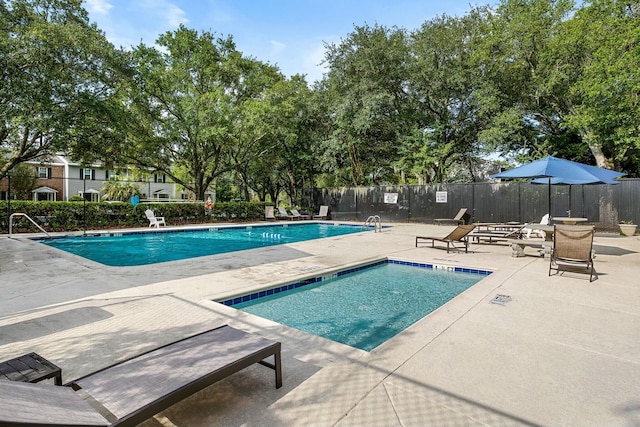 pool with a patio and fence