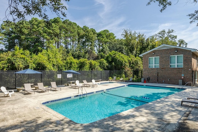 community pool featuring a patio area and fence