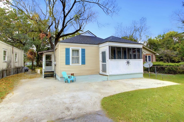 back of property featuring a sunroom, a yard, and a patio