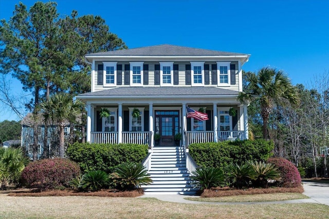 view of front of property featuring covered porch, stairway, and roof with shingles