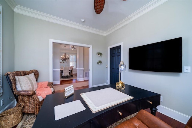 living area featuring ceiling fan with notable chandelier, wood finished floors, visible vents, baseboards, and crown molding