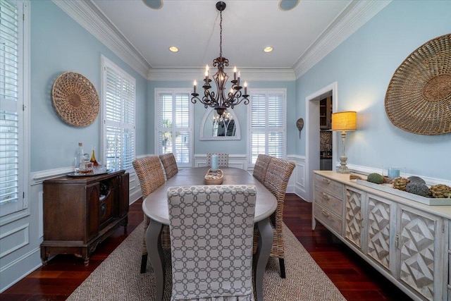 dining space featuring dark wood-style flooring, a notable chandelier, recessed lighting, ornamental molding, and wainscoting