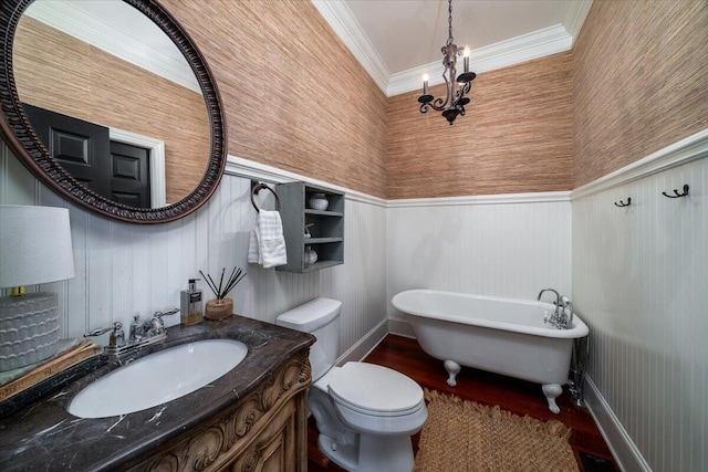 full bathroom featuring toilet, crown molding, vanity, a soaking tub, and an inviting chandelier