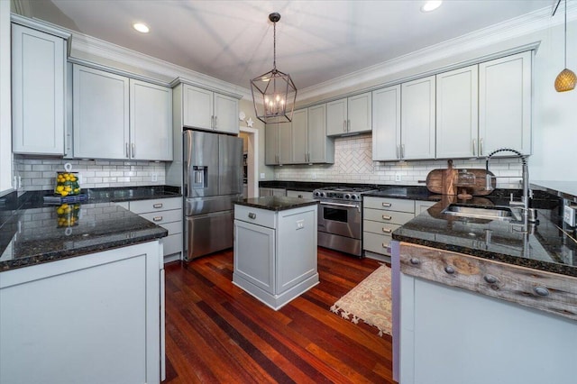 kitchen with stainless steel appliances, a sink, tasteful backsplash, dark wood finished floors, and crown molding