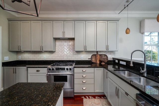 kitchen featuring stainless steel appliances, backsplash, a sink, and pendant lighting