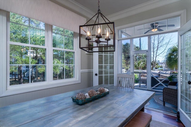 dining space featuring ornamental molding, dark wood-type flooring, and ceiling fan with notable chandelier