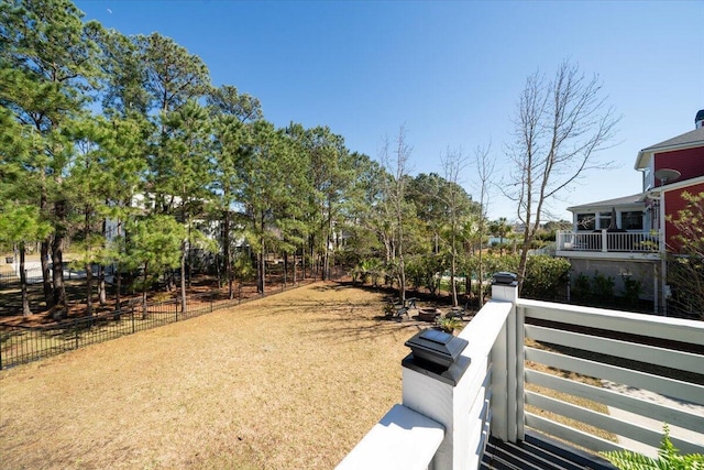 view of yard featuring a balcony and fence