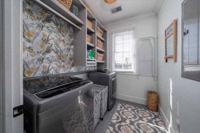 clothes washing area featuring laundry area, separate washer and dryer, visible vents, baseboards, and crown molding