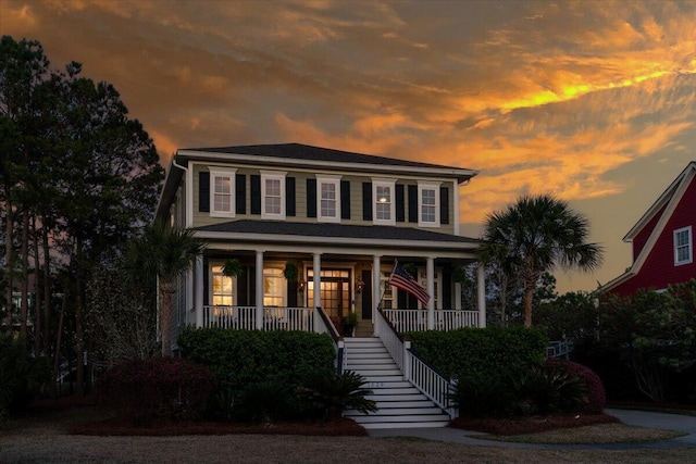 colonial home featuring covered porch and stairway