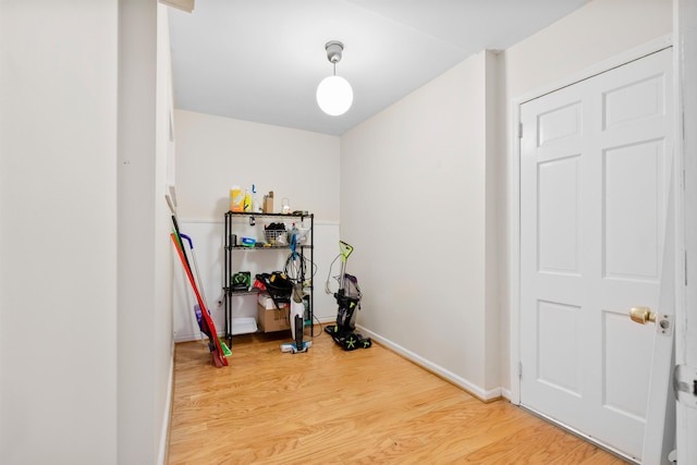 workout room with light wood-style flooring and baseboards