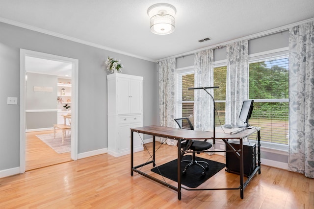 office space featuring healthy amount of natural light, ornamental molding, light wood-style flooring, and baseboards