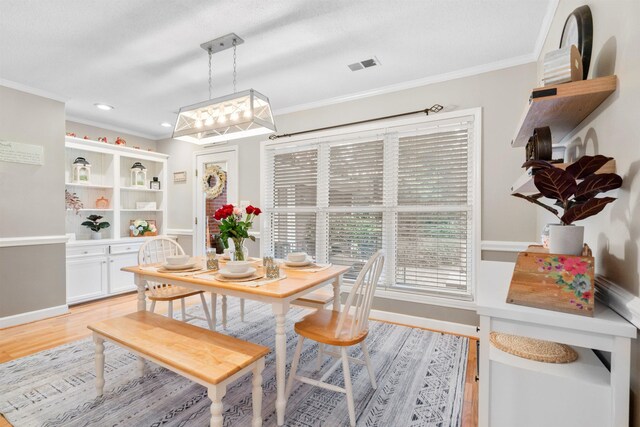 dining area featuring crown molding, light wood-style flooring, recessed lighting, and baseboards