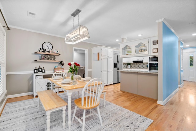 dining area with crown molding, light wood-style flooring, baseboards, and recessed lighting