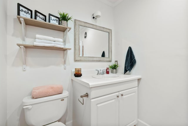 bathroom with vanity, toilet, and ornamental molding