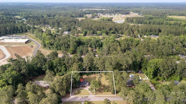 aerial view of property and surrounding area featuring a heavily wooded area and property parcel outlined