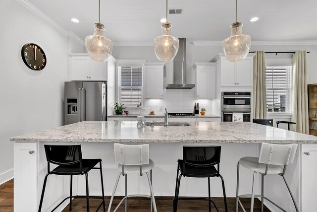 3529 Habenaria Rd Unit 33, Mount Pleasant, SC 29466 - kitchen with stainless steel appliances, wall chimney range hood, a large island with sink, ornamental molding, and tasteful backsplash