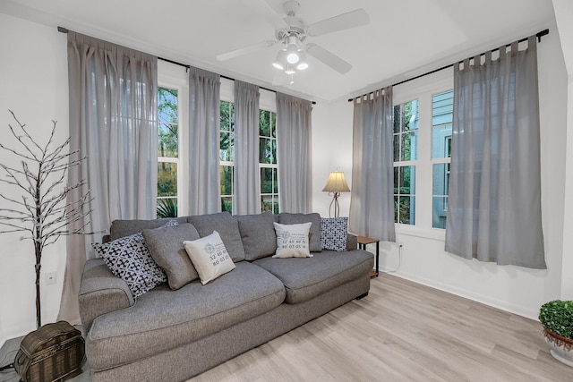 living room with a ceiling fan, wood finished floors, and baseboards