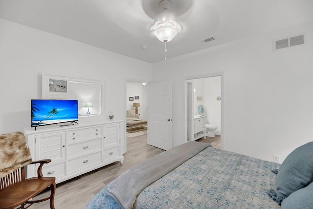 bedroom featuring light wood-style flooring, visible vents, and ensuite bathroom