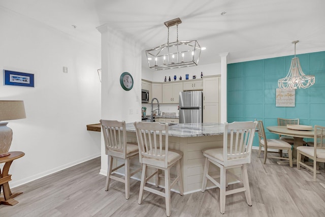 kitchen featuring light wood-type flooring, stainless steel appliances, a kitchen breakfast bar, and a peninsula