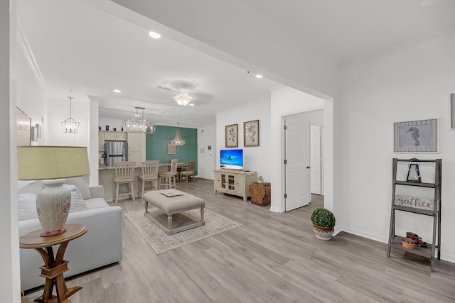 living area with recessed lighting, light wood-style flooring, baseboards, and ornamental molding