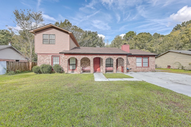 view of front of property featuring a front yard, fence, brick siding, and a chimney