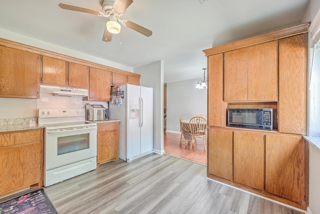 kitchen with ceiling fan with notable chandelier, under cabinet range hood, white appliances, light wood-style floors, and light countertops