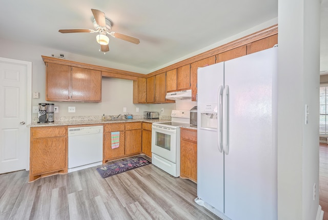 kitchen featuring light wood finished floors, under cabinet range hood, light countertops, brown cabinetry, and white appliances