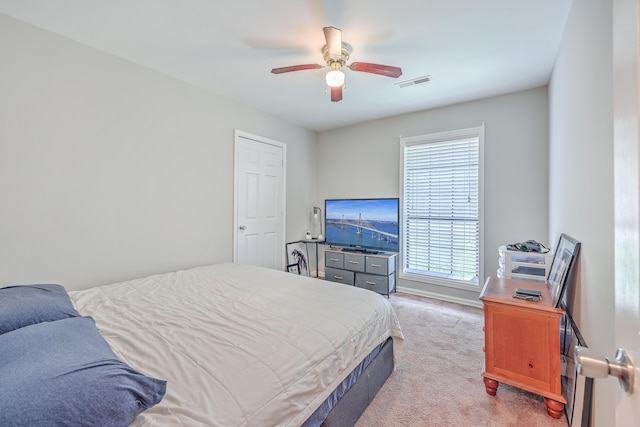 bedroom with baseboards, a ceiling fan, visible vents, and light carpet