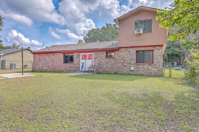 back of house with a lawn, a gate, fence, cooling unit, and brick siding