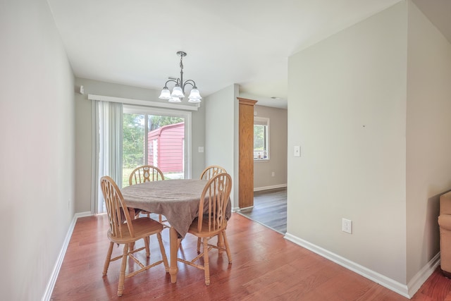 dining space with a chandelier, baseboards, and wood finished floors