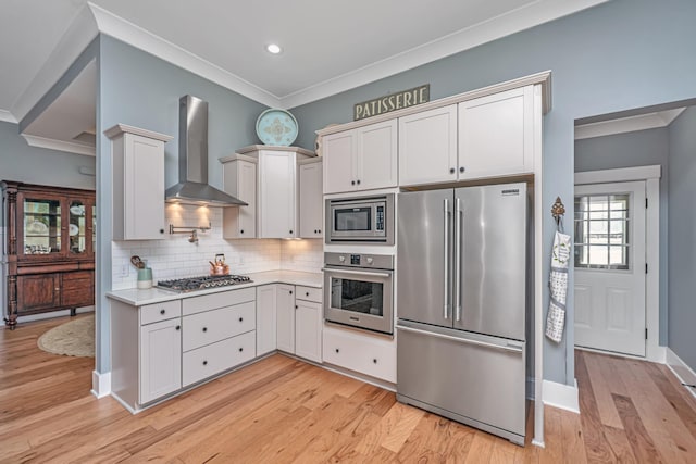 225 Camber Rd, Huger, SC 29450 - kitchen with appliances with stainless steel finishes, wall chimney range hood, crown molding, light countertops, and light wood-type flooring