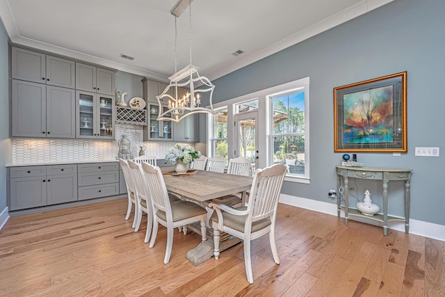 225 Camber Rd, Huger, SC 29450 - dining area with light wood finished floors, baseboards, crown molding, and a chandelier