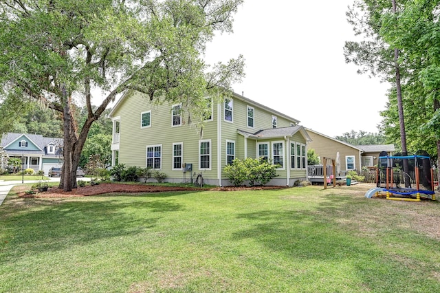 rear view of house with a playground and a lawn