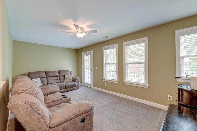 living room featuring plenty of natural light, baseboards, and light carpet
