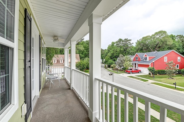 balcony featuring a porch, ceiling fan, and a residential view