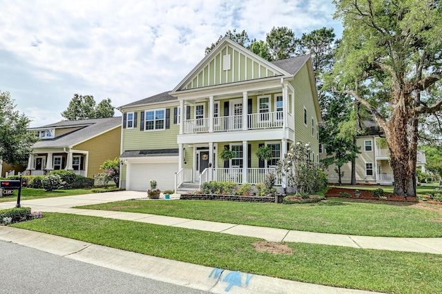view of front facade with a porch, an attached garage, concrete driveway, and a front lawn